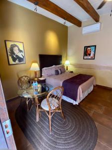 阿拉莫斯Hotel Casa María Félix的卧室配有一张床和一张桌子及椅子