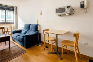巴约讷One bedroom appartement with wifi at Baiona的客厅配有蓝色的沙发和桌子