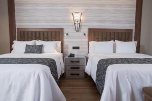 瓜达拉哈拉Hotel Ronda Minerva的酒店客房,配有两张带白色床单的床