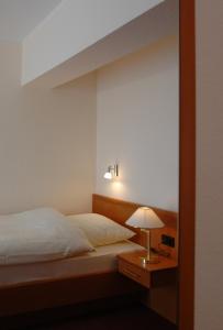 赖讷莱茵河-奥特斯塔德特德酒店的一间卧室配有一张床和一张桌子上的台灯