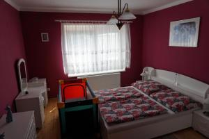 苏希采Domek Šumava的一间卧室设有一张床和红色的墙壁