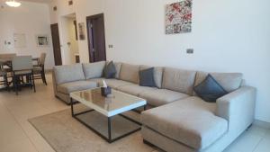 迪拜Azure Residences in Palm Jumairah的客厅配有沙发和桌子