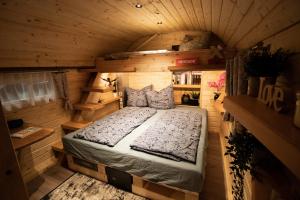 阿波尔达Röhrencamp Schöten/Apolda的木制客房内的一间卧室,配有一张床