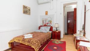 克拉多沃Etno Apartmani ''Vlaška kuća''的一间卧室配有一张床和红色地毯