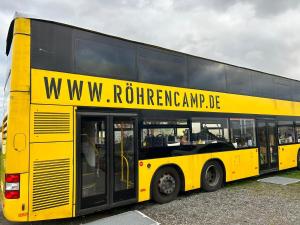 阿波尔达Röhrencamp Schöten/Apolda的停在停车场的黄色双层巴士