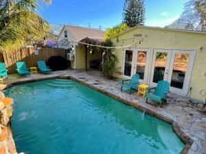 圣徒皮特海滩Laguna Azul - Sleeps 8 + Heated Pool + Walk to Beach的一个带椅子的游泳池以及一座房子