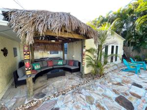 圣徒皮特海滩Laguna Azul - Sleeps 8 + Heated Pool + Walk to Beach的带沙发和茅草屋顶的天井