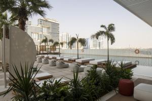 迪拜Business Travel Ready Studio at Upside Living的屋顶露台设有躺椅和棕榈树