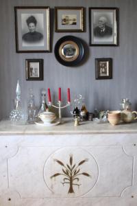 Marcilly le Chatel乐勒席奈特酒店的一张桌子,墙上挂着一些照片,还有红色蜡烛
