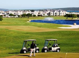 兰格班Ellefsen 134 Golf Paradise的高尔夫球手在高尔夫球场上用两辆高尔夫球车打球