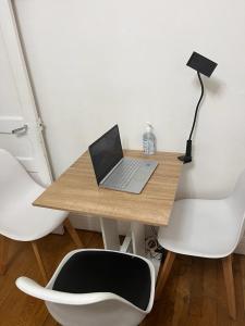 伊西莱穆利诺chambre d'hote的一张带笔记本电脑和两把白色椅子的桌子