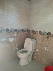 JaliapāraSurjasto Resort的浴室设有卫生间和配有娃娃的架子