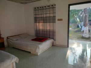 JaliapāraSurjasto Resort的一间卧室设有一张床和一个大窗户