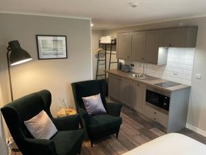 BressayMidgarth House Apartments的一间带两把椅子的客厅和一间厨房