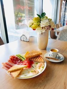 雅西MONARC Boutique ApartHotel - SELF CHECK-IN的一张桌子,上面有一盘早餐食品和花瓶