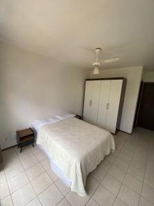 巴西利亚kitnet sudoeste proximo de comercios的卧室配有白色的床和橱柜。