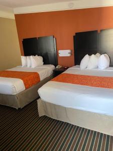 查尔斯湖查尔斯湖豪生国际酒店的酒店客房,设有两张带橙色墙壁的床