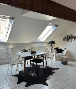 Spacieux duplex à Folschviller的客厅配有桌椅和天窗。