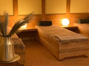 格罗尔斯泰因姆勒伯兰德酒店的一间设有两张床的房间和一个种植植物的花瓶