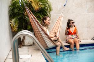 巴拿马城厄尔玛齐科旅馆的两个妇女在游泳池畔的吊床上休息