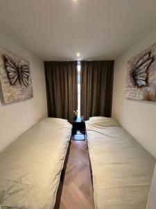 埃尔默洛Luxe boshuisje Arlo in Ermelo!的带窗户的客房内设有两张单人床。