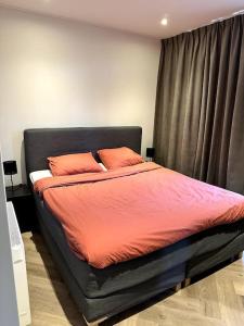 埃尔默洛Luxe boshuisje Arlo in Ermelo!的卧室内一张带橙色床单和橙色枕头的床
