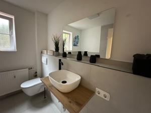 沙博伊茨Whg 1 Charmante Ferienwohnung in Scharbeutz -Ihr perfektes Zuhause am Meer的白色的浴室设有水槽和镜子