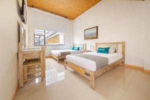 马尼萨莱斯Hotel Ana Carolina的一间卧室设有两张床和窗户。