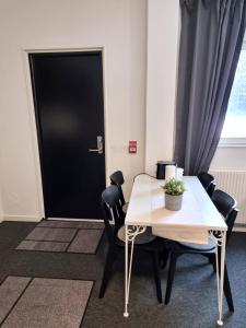 TimråRentalux Apartments at Vivansborg的配有桌椅和黑色门的房间