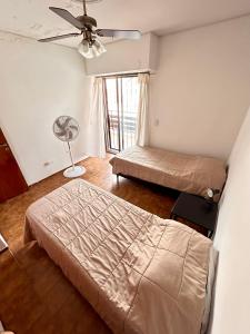 门多萨"GRANADEROS" - GH Departamentos的一间卧室配有两张床和风扇