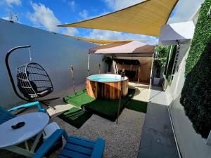 庞塞Astrolax Cinema with Jacuzzi & 4D Massage Chair的庭院设有热水浴池、桌子和椅子。
