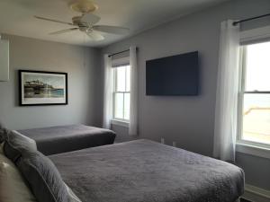 新肖雷汉姆民族酒店的一间卧室配有两张床和一台平面电视