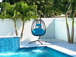 迈阿密Lux Backyard/Heated Pool/Everglades/Speedway/Keys!的游泳池旁的蓝色椅子