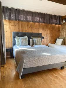 霍芬豪卡贝格旅馆的一间卧室设有两张床和木墙