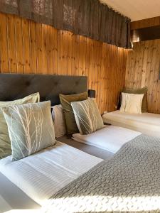 霍芬豪卡贝格旅馆的木墙客房的两张床