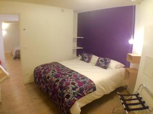 巴黎蓝色之家公寓的一间卧室配有一张紫色墙壁的床