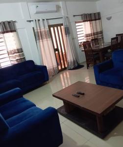 科托努Magnifique Maison de ville Bord de mer Cotonou Fidrjossè的客厅配有蓝色的沙发和咖啡桌