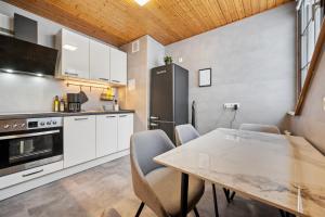 新安斯波Wohnung Weitblick的厨房配有白色橱柜和桌椅