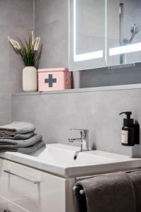新安斯波Wohnung Weitblick的浴室设有白色水槽和墙壁上的十字架