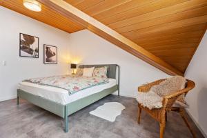 新安斯波Wohnung Weitblick的一间卧室设有一张床和木制天花板