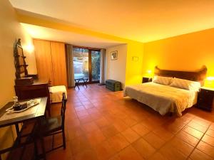 弗雷舒德埃什帕达阿辛塔柳树农场住宿加早餐旅馆 - 乡村旅游的一间卧室设有黄色的墙壁、一张床和一张桌子