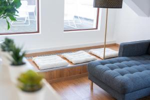 维也纳Luxury Penthouse - Augarten的客厅配有蓝色沙发和白色枕头。
