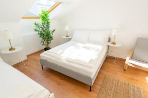 维也纳Luxury Penthouse - Augarten的一间卧室配有一张带白色床单的床和一扇窗户。