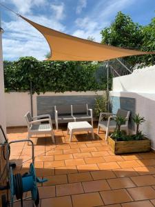 托里代巴拉3 bedrooms house at Torredembarra 1 km away from the beach的庭院配有桌椅和黄色雨伞。