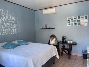 雅科Hotel Perico Azul & Surf Camp的一间卧室配有一张床和一张桌子