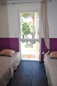滨海阿热莱斯Appartement de 2 chambres avec piscine partagee terrasse et wifi a Argeles sur Mer a 3 km de la plage的一间卧室设有两张床和大窗户