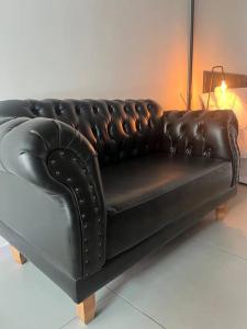 里约热内卢Casa do Coité的一张坐在房间里黑色皮沙发