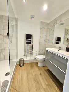 剑桥Kiwi Tree Serviced Apartment的浴室配有卫生间、盥洗盆和淋浴。