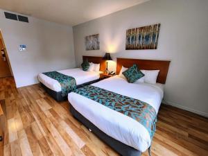 坎莫尔日落山酒店 的配有2张床的酒店客房,铺有木地板