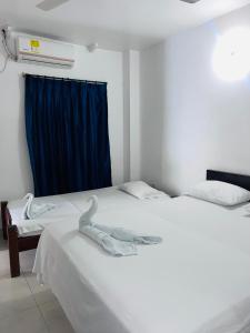 巴兰卡韦梅哈HOTEL COLONIAL的一间卧室配有两张床和蓝色窗帘